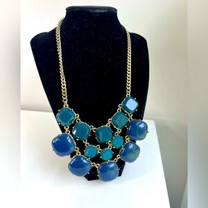 Blue and gold stone bib necklace. Blue stones in gold metal. Clasp close chain.